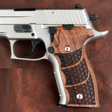 Sig Sauer P229 semi-automatic handgun with polished silver slide and dark brown custom wood grips with check pattern.