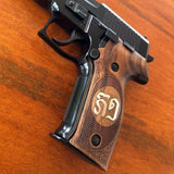 Walnut wood Sig Sauer P228 custom grips with silver logo inlay, designed for enhanced grip and aesthetic appeal.